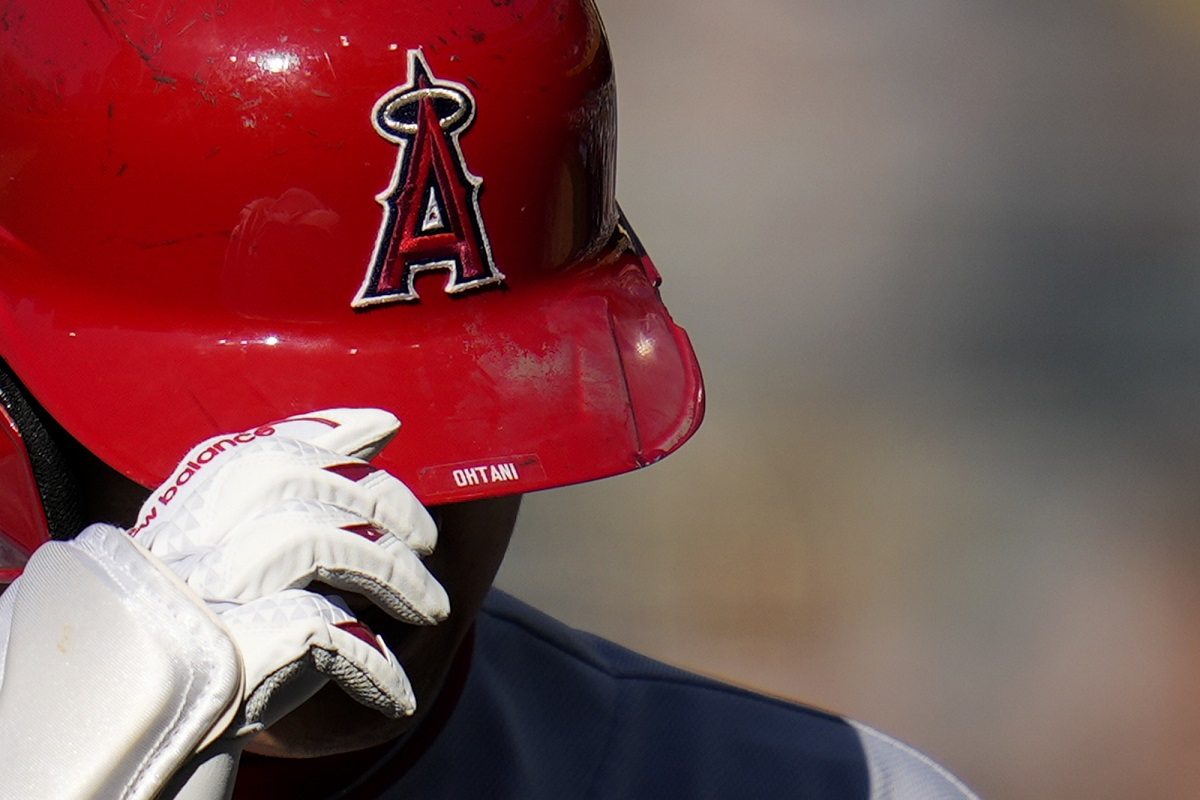 Shohei Ohtani (R) of the Los Angeles Angels hands his protective